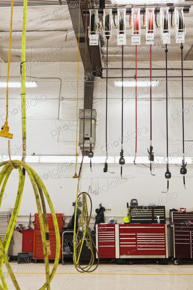 A vehicle repair shop with equipment, hoses and electrical wiring.