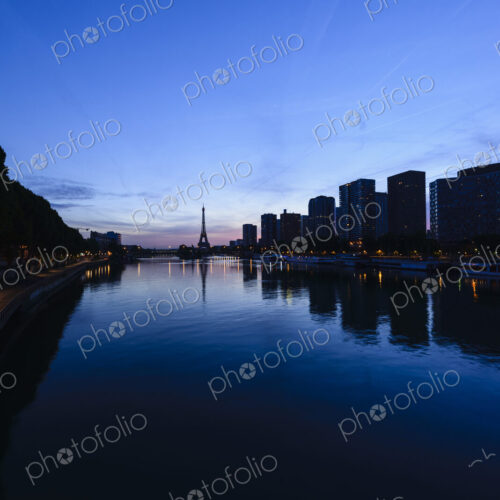 A view along the water of the River Seine at night, tall buildings on the river bank,… A view along the water of the River Seine at night, tall buildings on the river bank,…