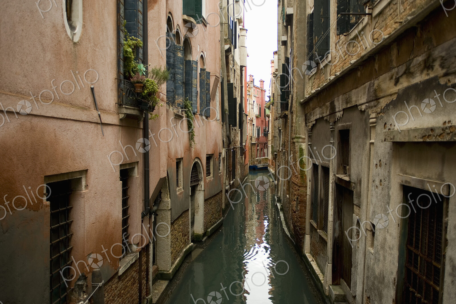 A view from above of a quiet backwater, a narrow canal with historic buildings rising…