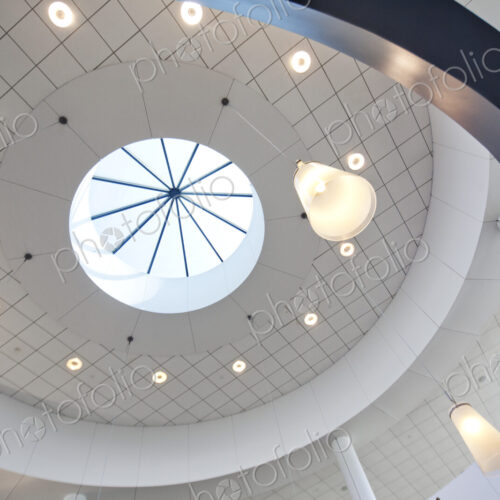 A view from below to a round dome ceiling with a central skylight. A view from below to a round dome ceiling with a central skylight.