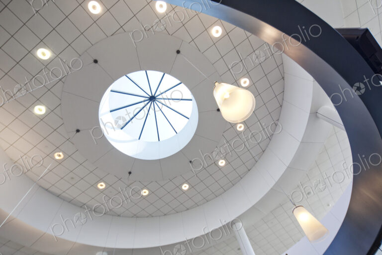 A view from below to a round dome ceiling with a central skylight.