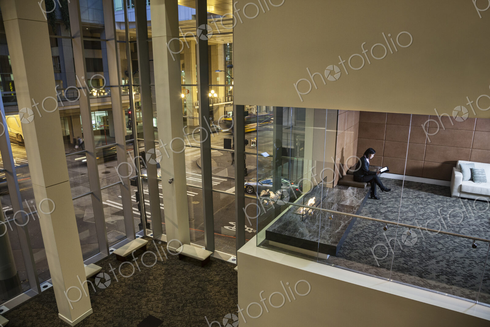 A view looking down into a conference room with a business woman looking at a notebook…