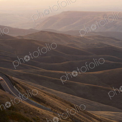 A view looking down of a car moving on a highway at sunrise near Lewiston, Idaho USA.