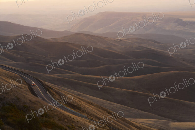 A view looking down of a car moving on a highway at sunrise near Lewiston, Idaho USA.