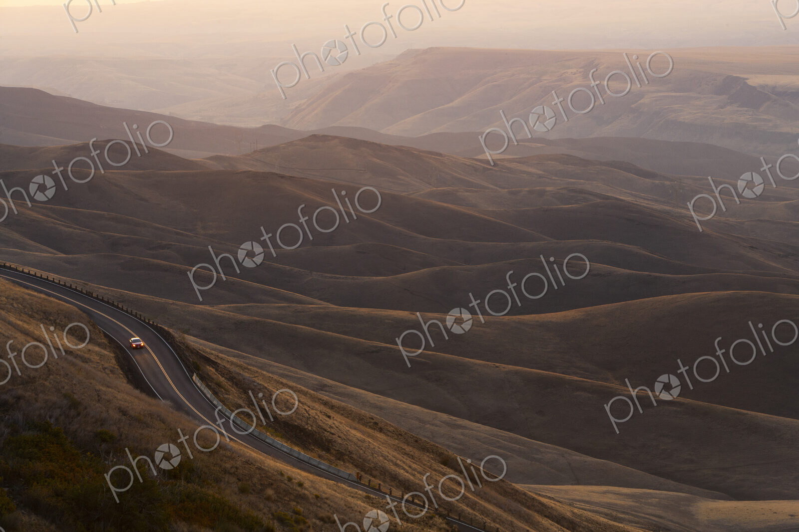 A view looking down of a car moving on a highway at sunrise near Lewiston, Idaho USA.