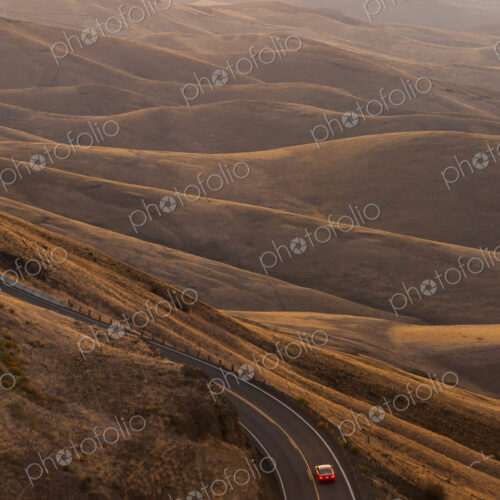 A view looking down of a car moving on a highway at sunrise near Lewiston, Idaho USA.