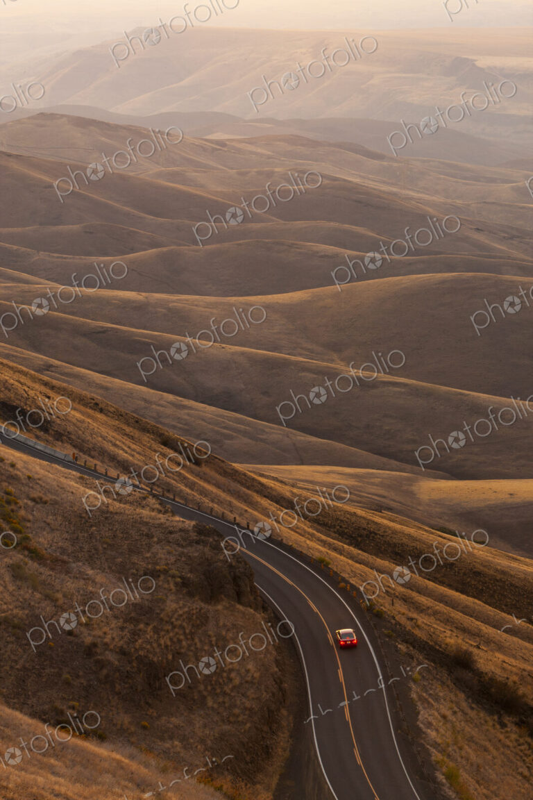 A view looking down of a car moving on a highway at sunrise near Lewiston, Idaho USA.