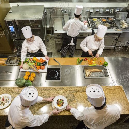 A view looking down on a crew of chefs working in a commercial kitchen, A view looking down on a crew of chefs working in a commercial kitchen,