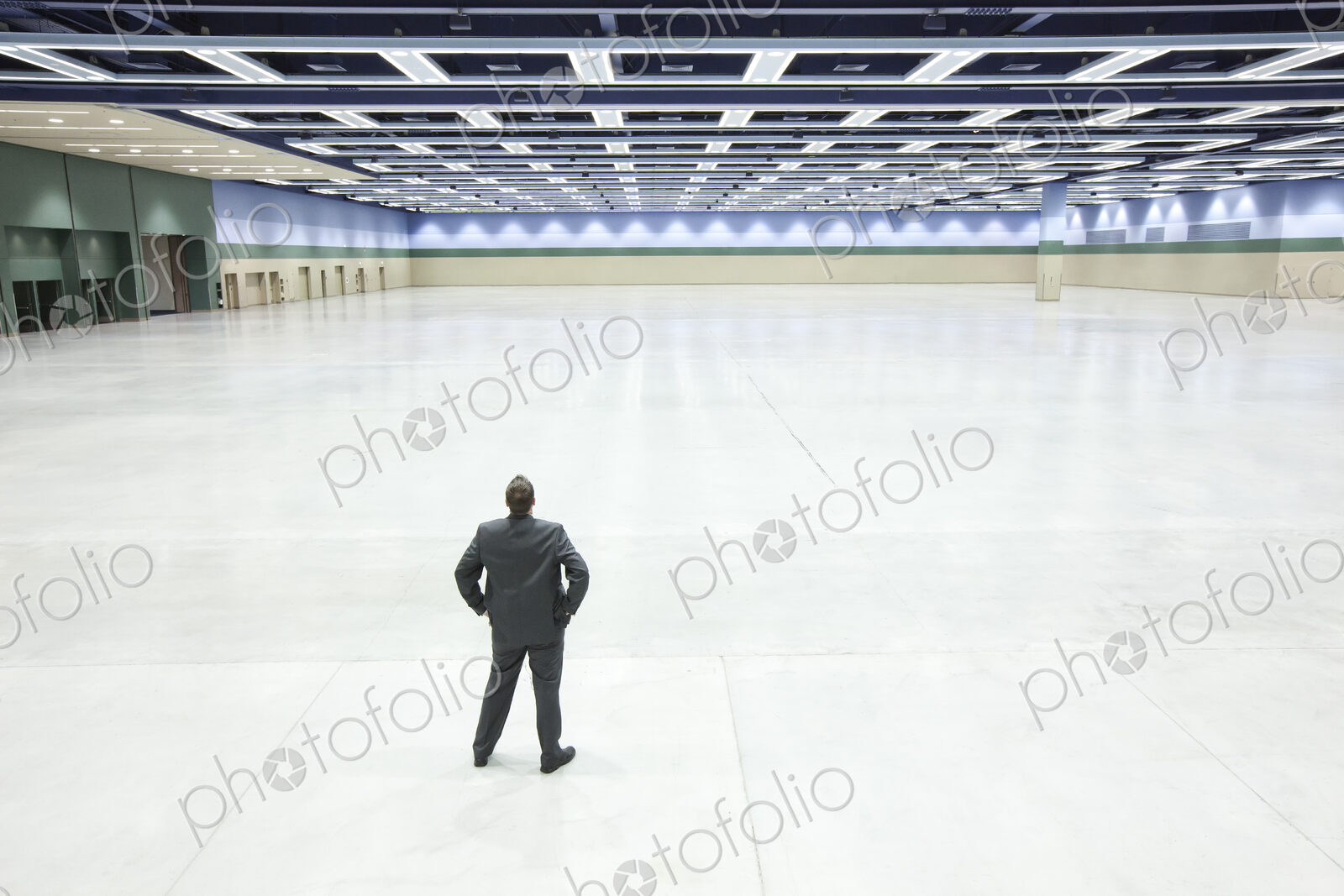 A view looking down on a single businessman surveying the interior of a convention…