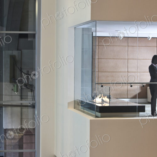 A view looking into a converence room at night with an Asian businesswoman at work. A view looking into a converence room at night with an Asian businesswoman at work.