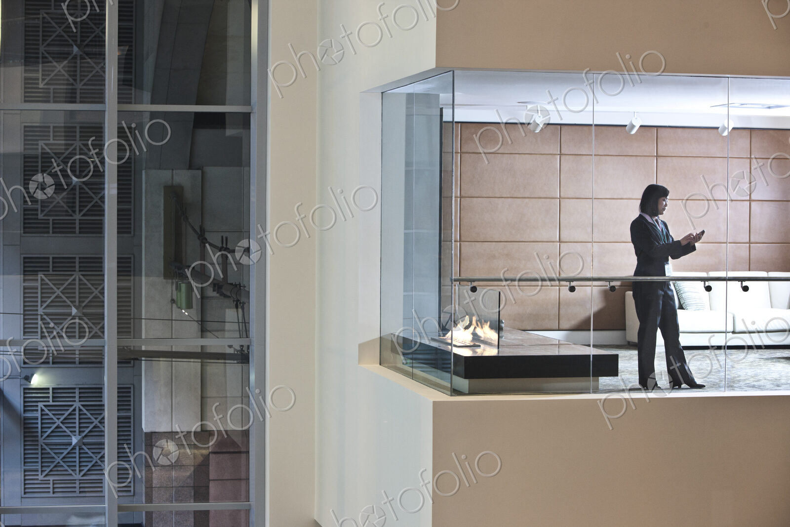A view looking into a converence room at night with an Asian businesswoman at work.