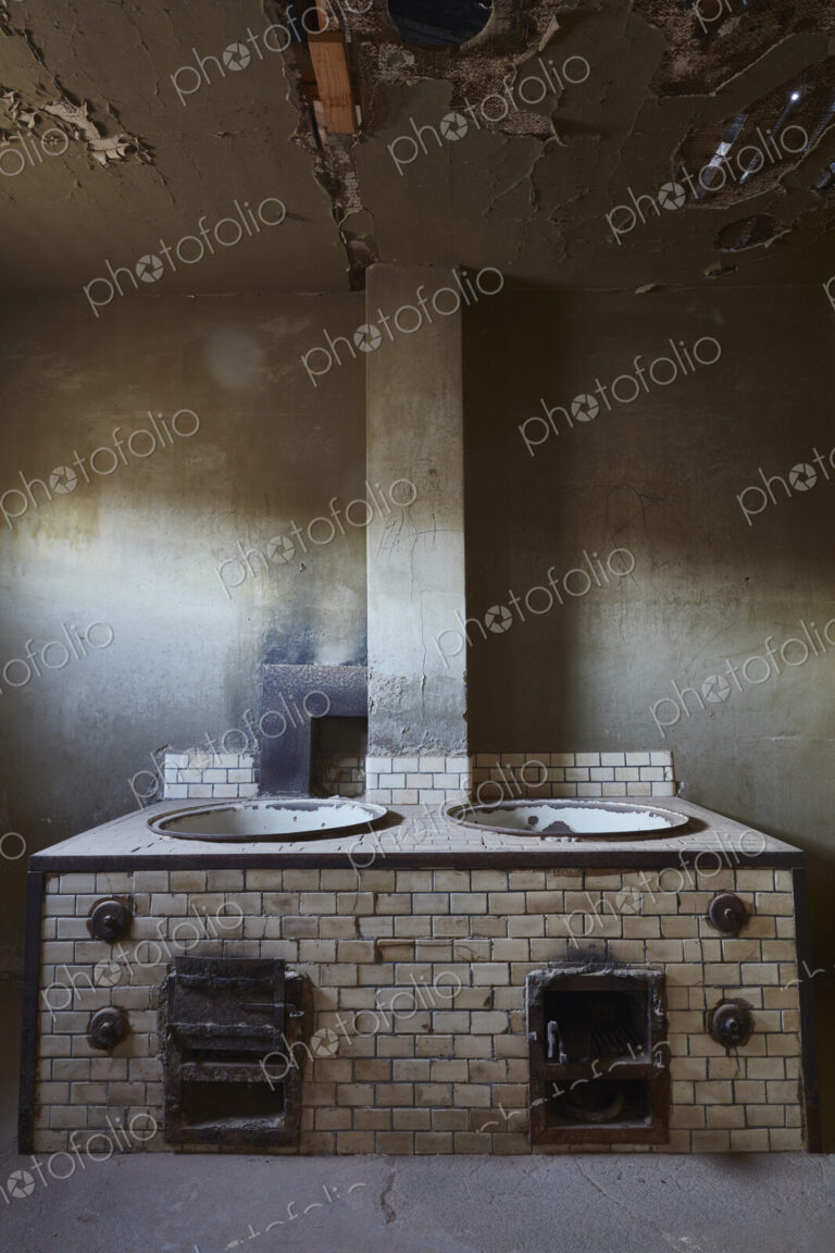 A view of an old fashioned stove in a derelict building.