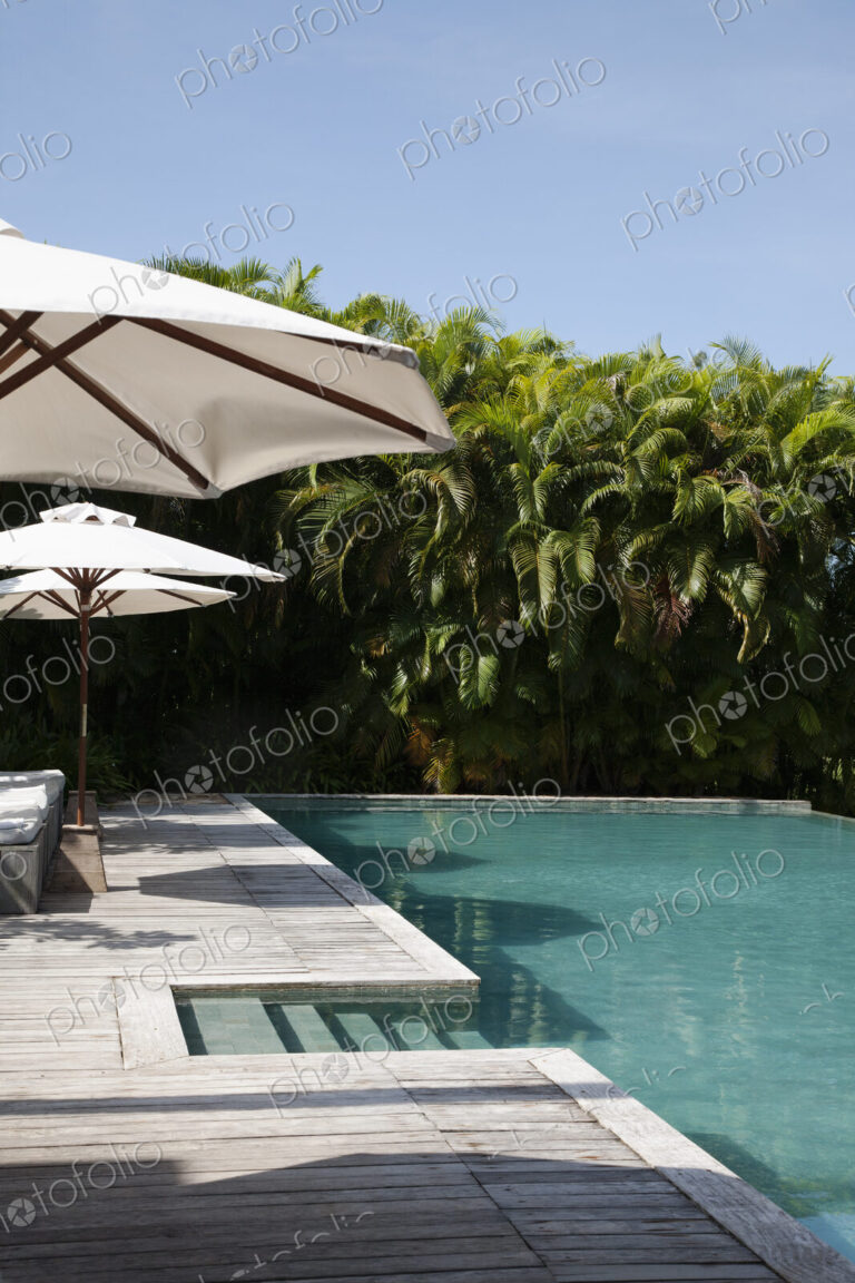 A view of the infinity pool and umbrellas at a hotel.