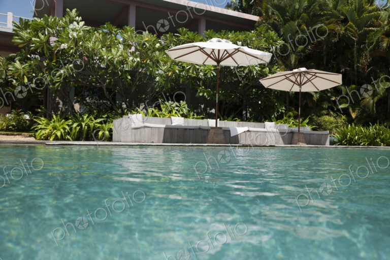 A view of the infinity swimming pool and umbrellas at a hotel.