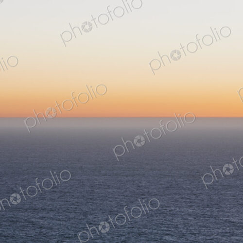 A view over the Pacific Ocean and the sunset on the horizon.