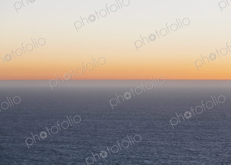 A view over the Pacific Ocean and the sunset on the horizon.