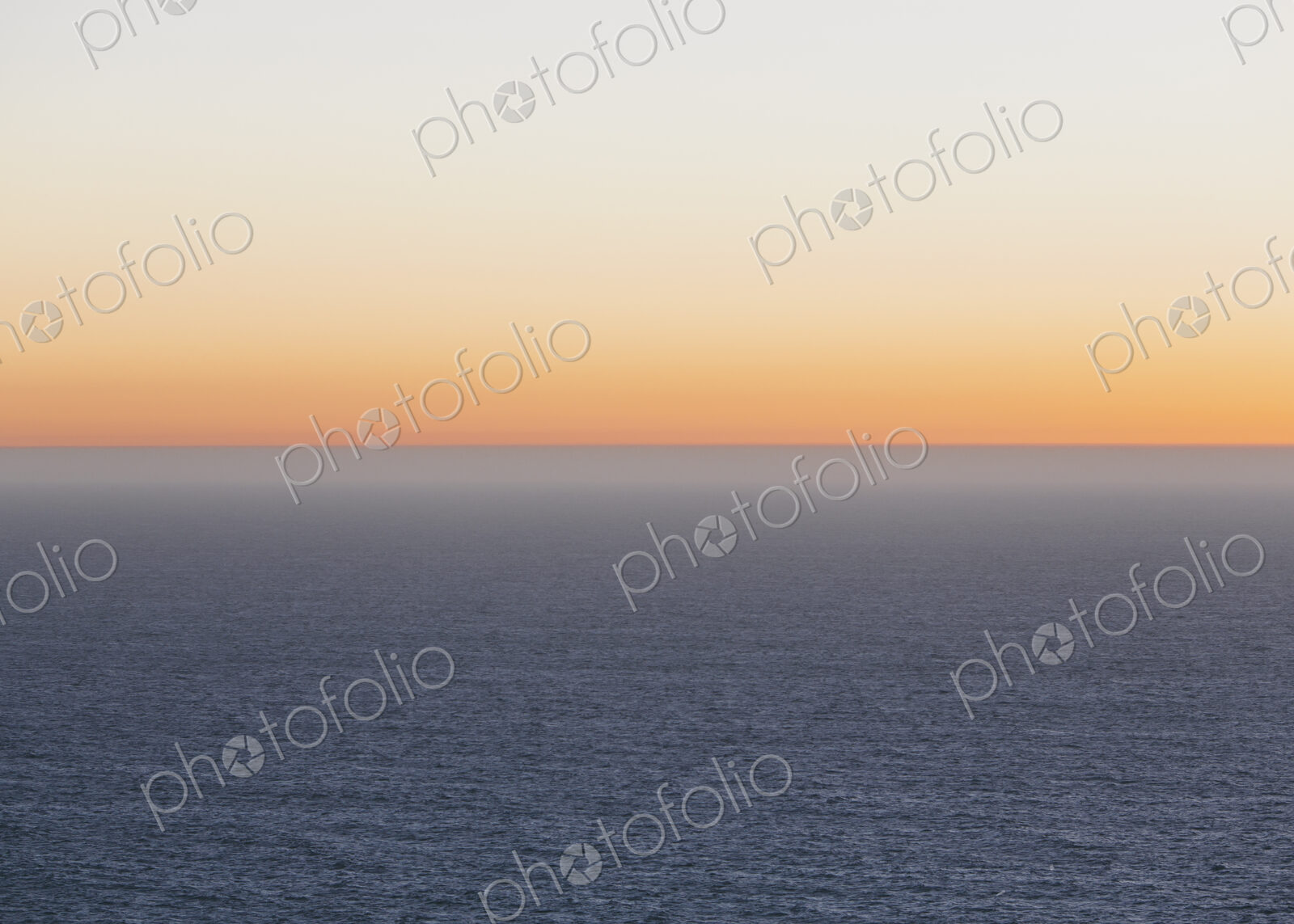 A view over the Pacific Ocean and the sunset on the horizon.