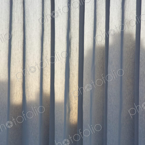 A view over the buildings of downtown Vancouver, shadows seem through vertical blinds…