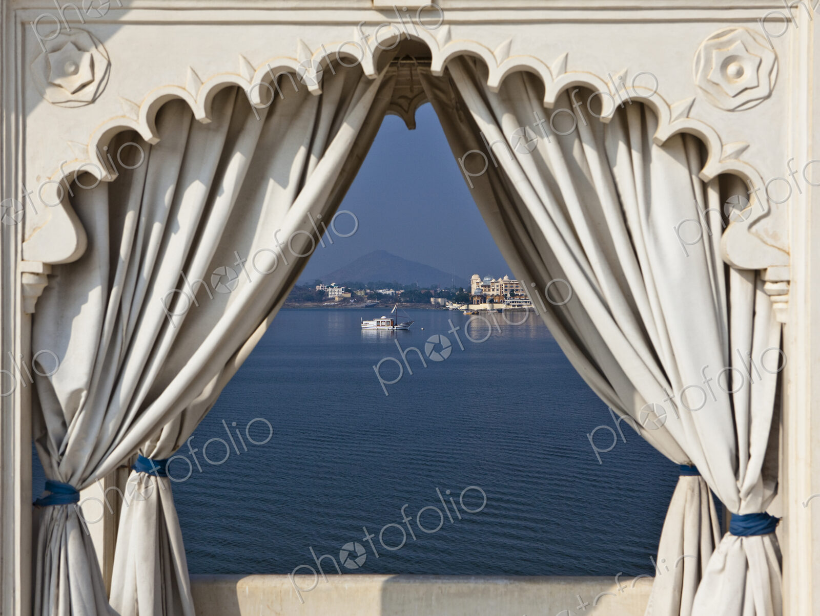 A view through a traditional scalloped edged archway, with curtains drawn back, view…