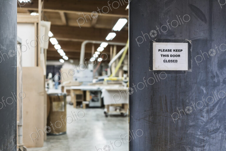 A walkway between two shops in a large woodworking factory.