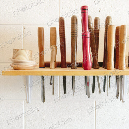 A wall mounted rack full of wood working hand tools.