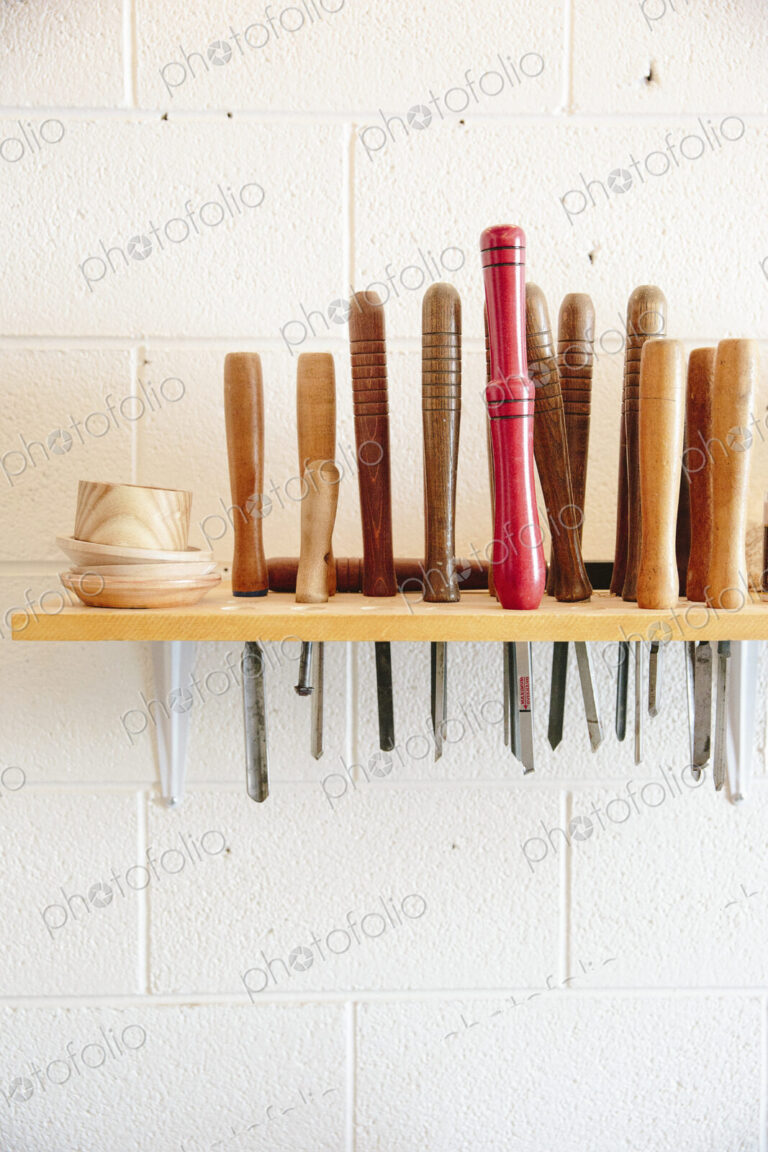 A wall mounted rack full of wood working hand tools.