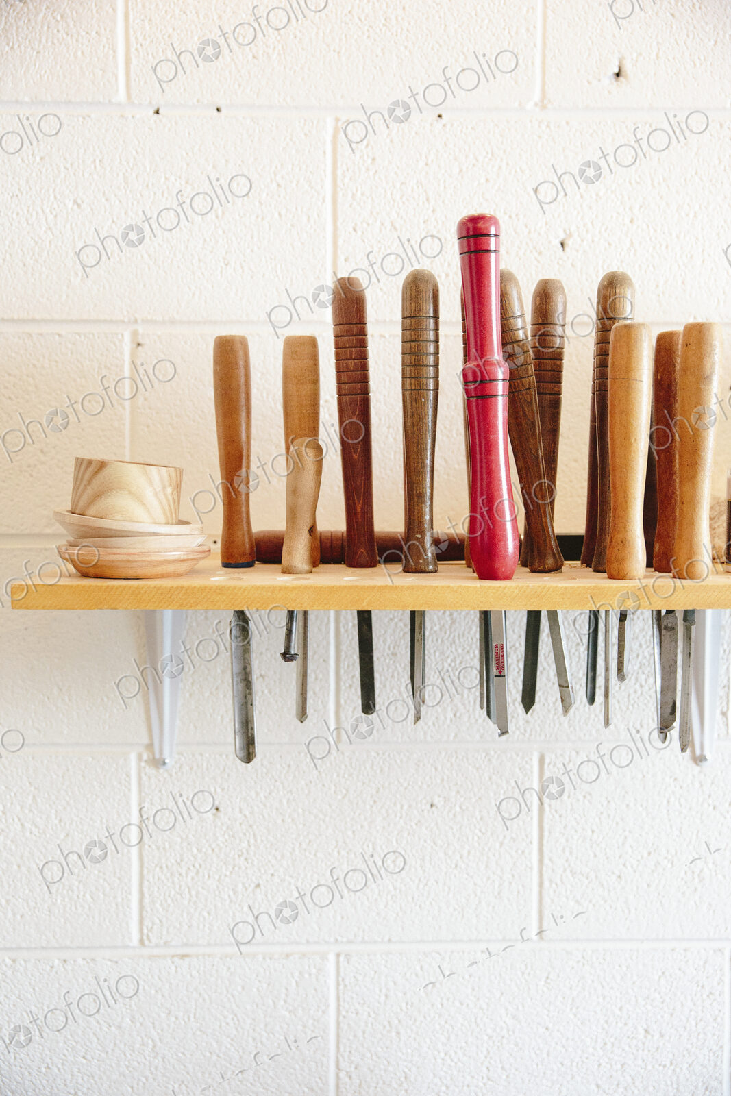 A wall mounted rack full of wood working hand tools.