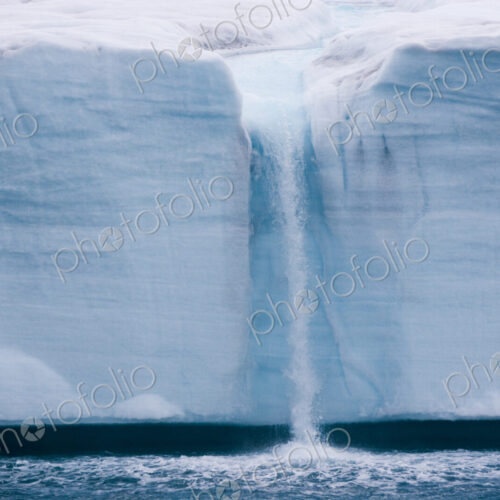 A waterfall is created by a melting iceberg, Svalbard, Norway A waterfall is created by a melting iceberg, Svalbard, Norway