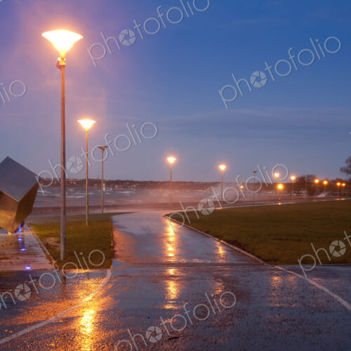 A weather storm, rain and waves crashing over the waterfront promenade and coastline