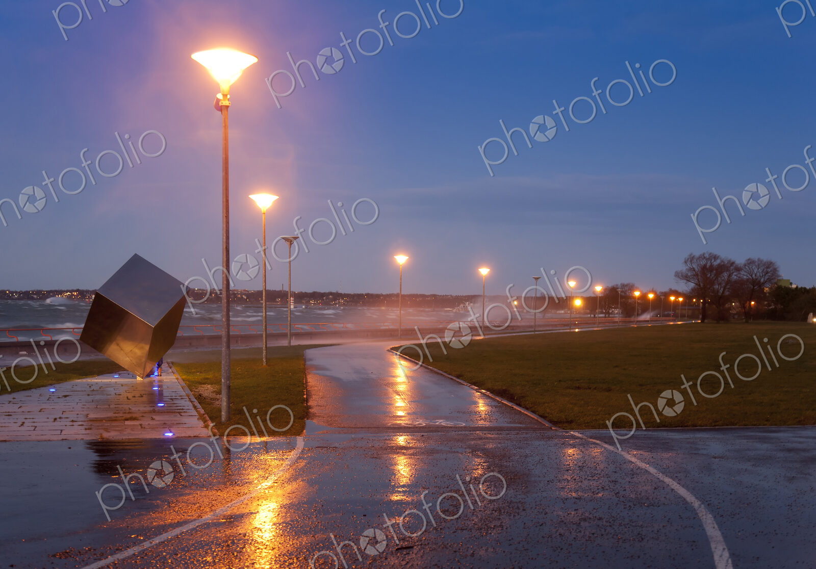 A weather storm, rain and waves crashing over the waterfront promenade and coastline