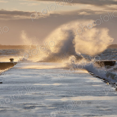 A weather storm, waves crashing over a waterfront promenade and coastline A weather storm, waves crashing over a waterfront promenade and coastline