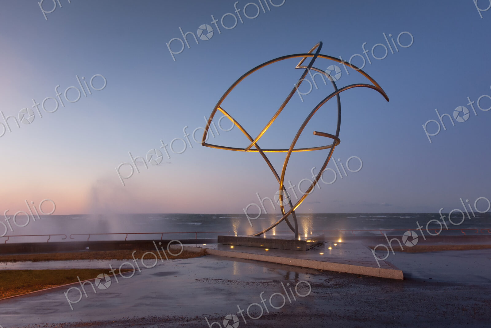 A weather storm, waves crashing over the waterfront promenade and metal sculpture