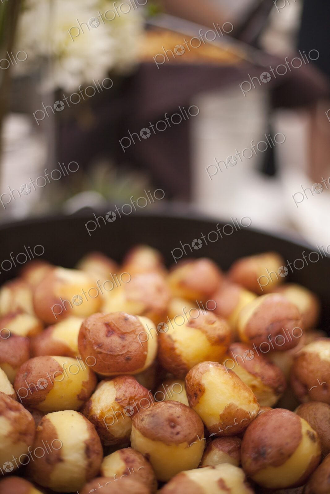 A wedding buffet meal. A dish of partly peeled new potatoes.