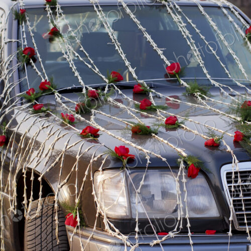 A wedding car decorated with red and white flowers. A wedding car decorated with red and white flowers.