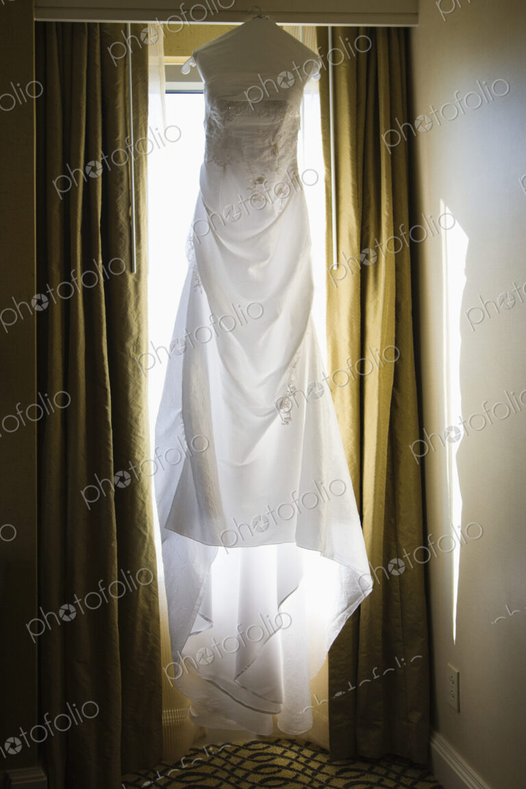 A wedding dress hanging up in a window