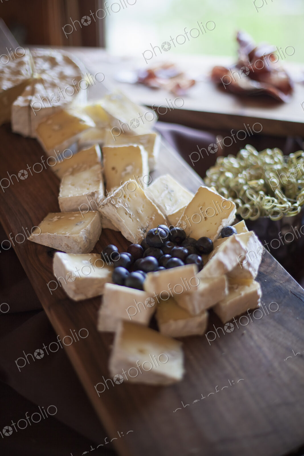 A wedding party meal. A cheeseboard, with soft cheeses cut into triangles, and fresh…
