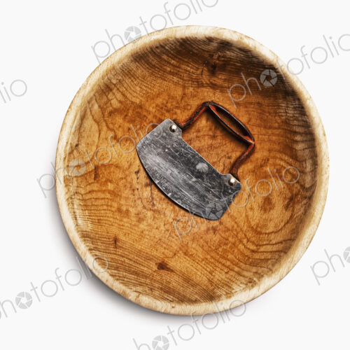 A well worn wooden chopping bowl, with a steel blade and handle.