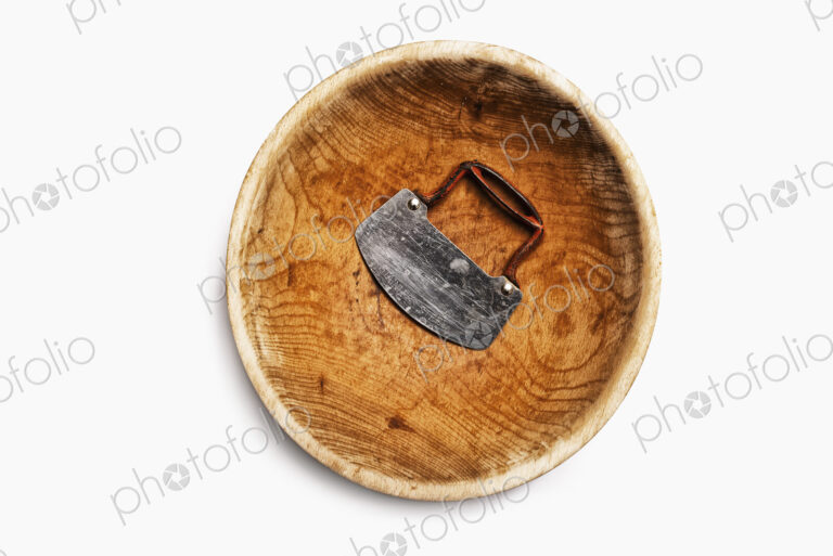 A well worn wooden chopping bowl, with a steel blade and handle.