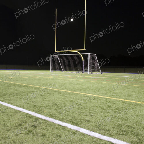 A white ball between the posts on a sports field, scoring A white ball between the posts on a sports field, scoring