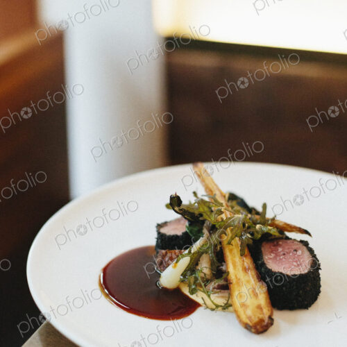 A white plate with a cooked dish of meat and vegetables.