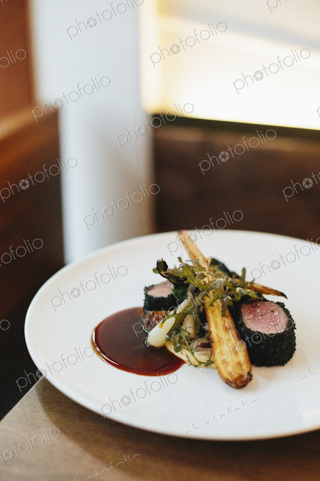A white plate with a cooked dish of meat and vegetables.