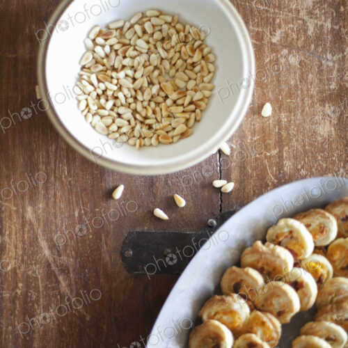 A white pottery bowl, full of dried corn kernels. A dish of baked pastries. A white pottery bowl, full of dried corn kernels. A dish of baked pastries.