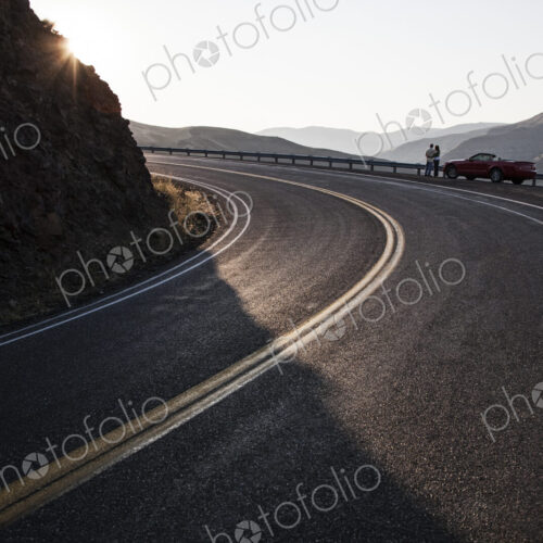 A wide view of a couple enjoying the scenery at a rest stop on a highway
