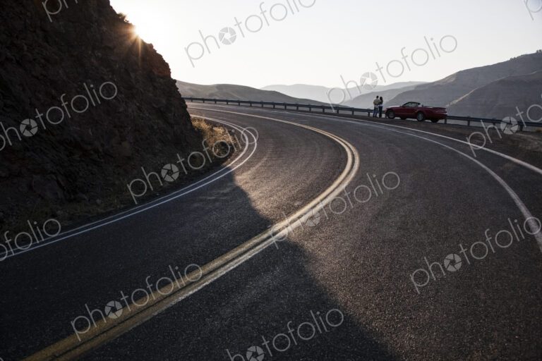 A wide view of a couple enjoying the scenery at a rest stop on a highway