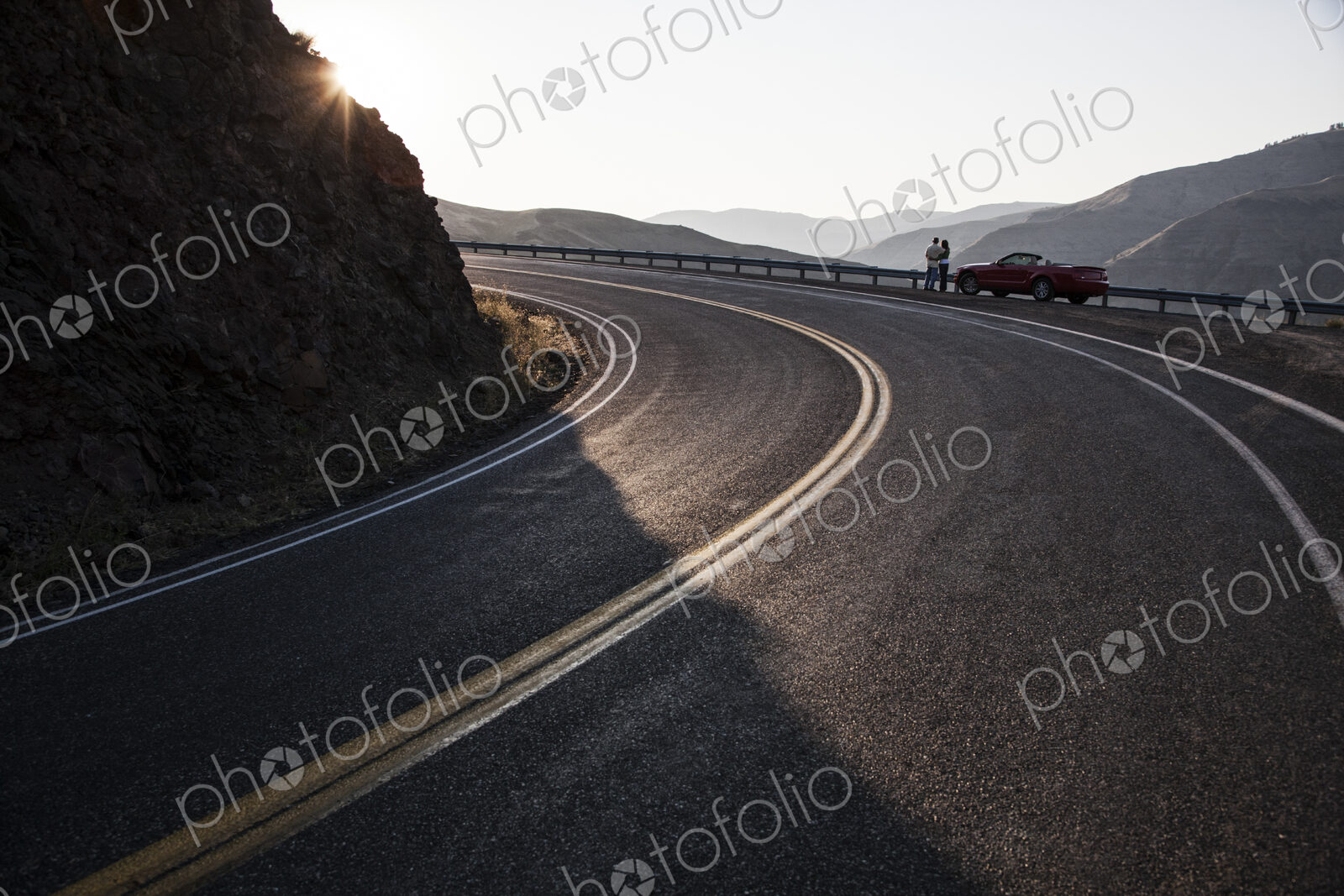 A wide view of a couple enjoying the scenery at a rest stop on a highway