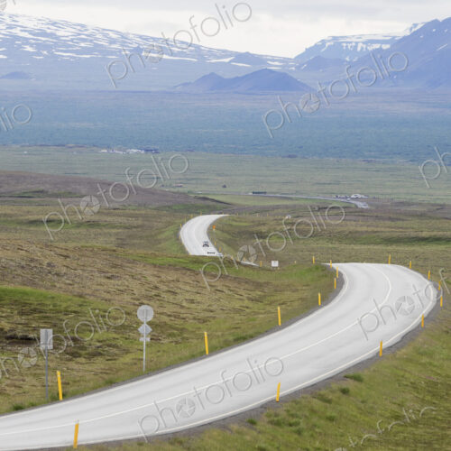 A winding mountain road through an open space.