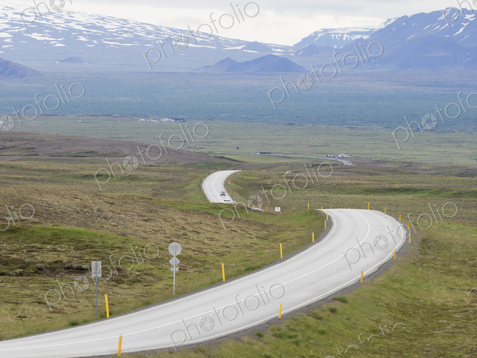 A winding mountain road through an open space.