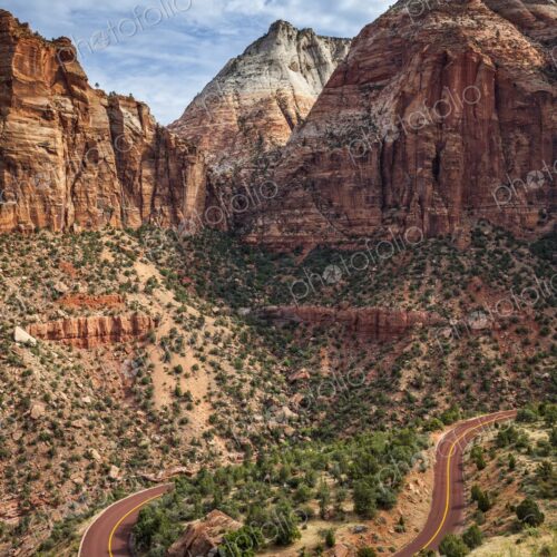 A winding switchback road cuts through the rugged terrain of Zion National Park,… A winding switchback road cuts through the rugged terrain of Zion National Park,…