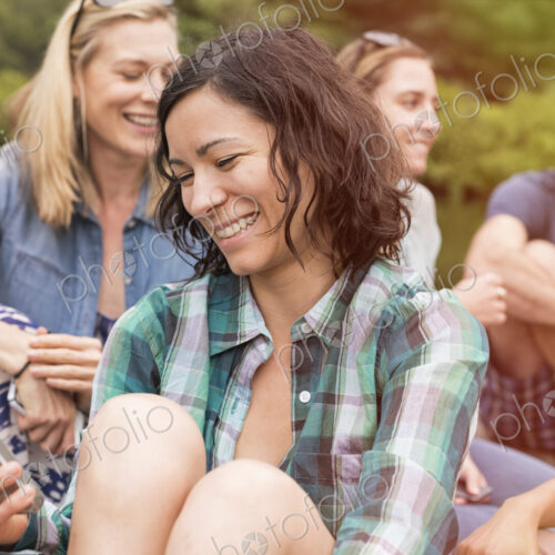 A woman among a group in summer using her smart phone. A woman among a group in summer using her smart phone.
