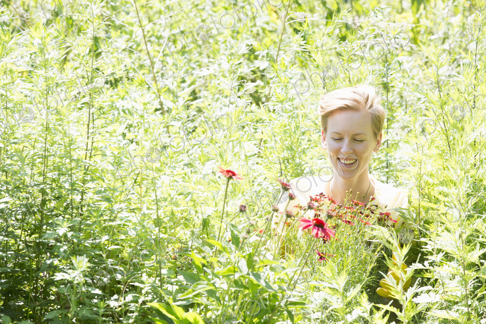 A woman among dense plantings of flowers and tall green and flowering plants